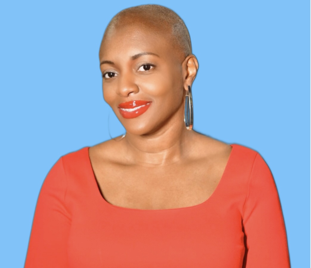 Headshot of Nikki from homepage. She’s smiling, wearing a red top and red lipstick.